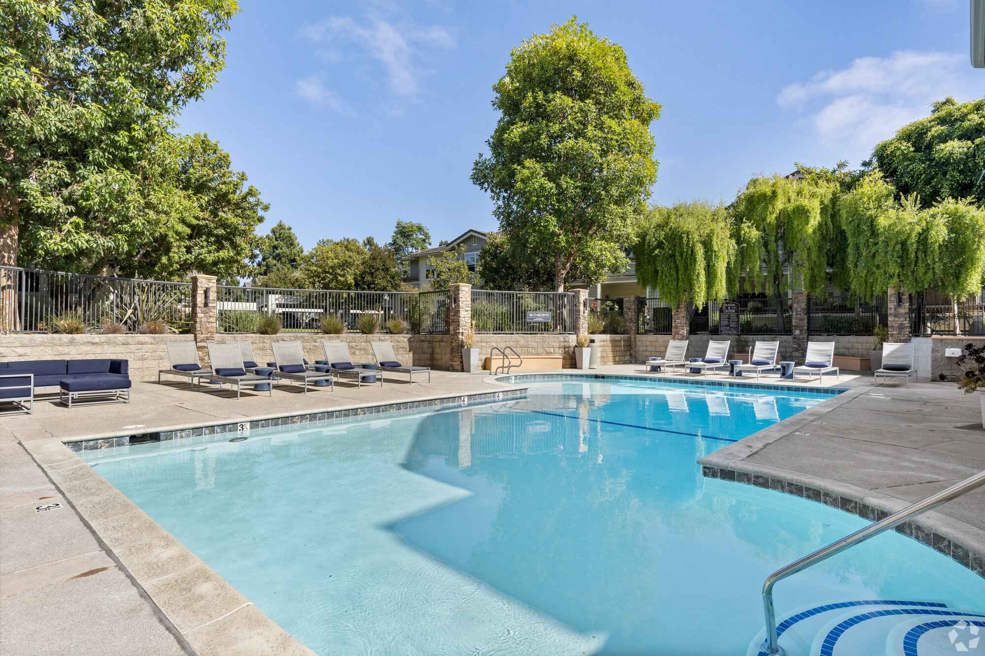 sparkling swimming pool with lounge chairs at Via Ventura