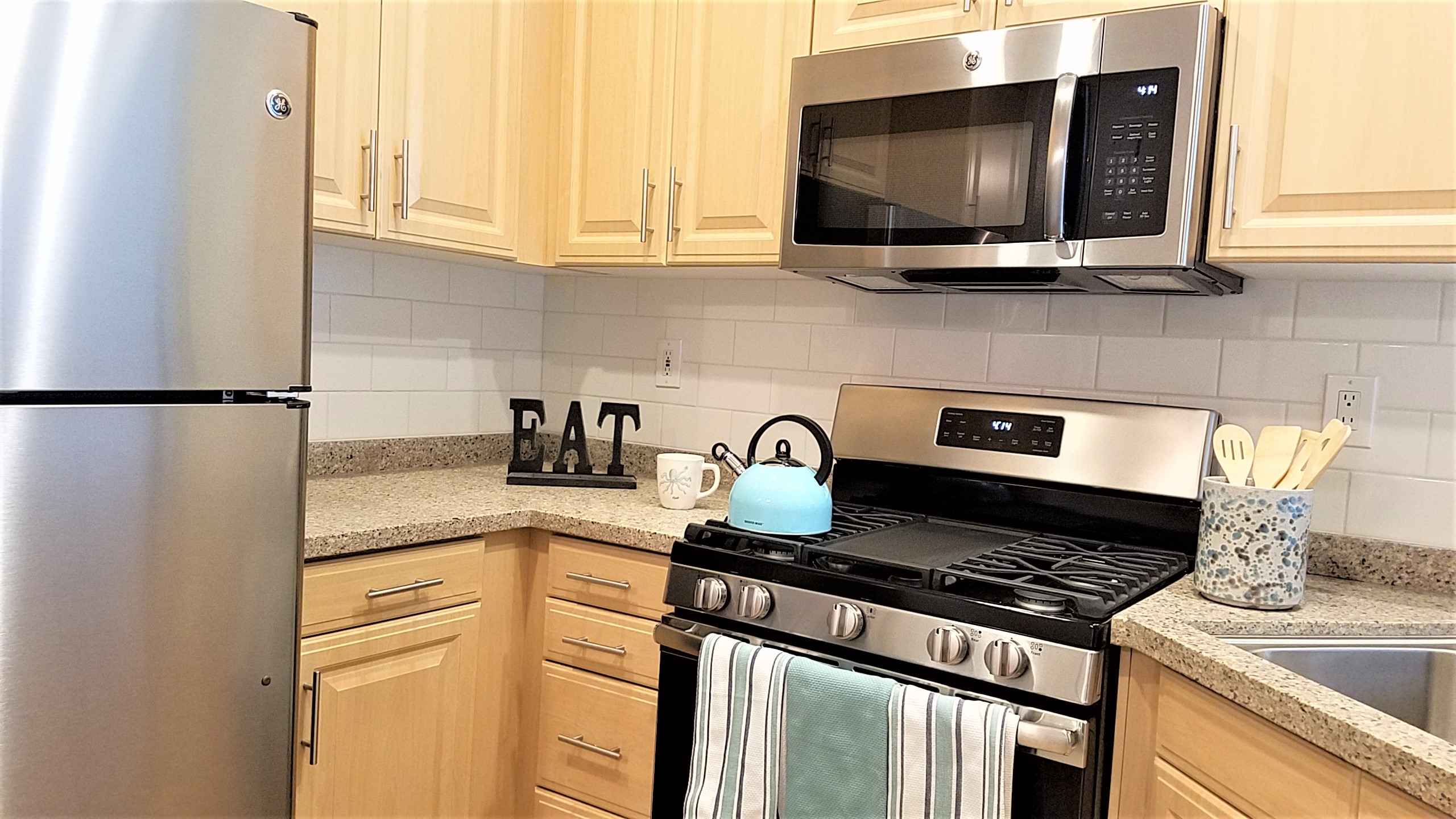 close up of gas range and wood cabinets at Via Ventura