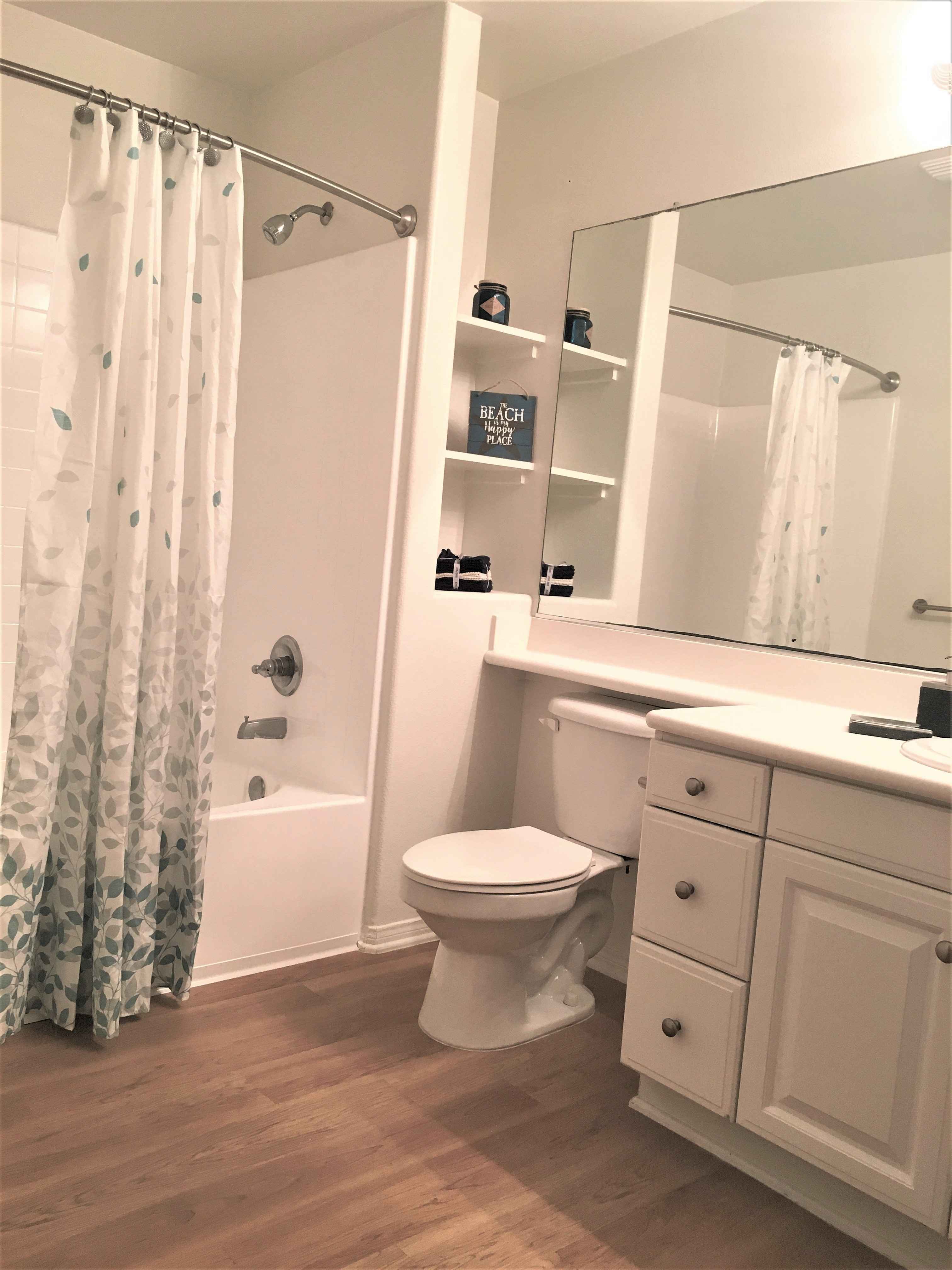 modern bathroom with hardwood style flooring at Via Ventura